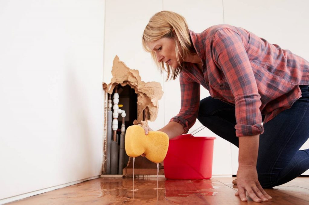 Woman wiping up water from floor